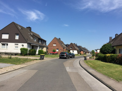 Eine ruhig gelegene Wohnsiedlung mit freistehenden Häusern, Vorgärten und wenig parkenden Autos