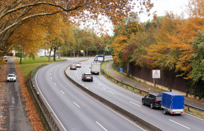 Foto einer Bundesstraße, mehrere Autos fahren durch eine Kurve